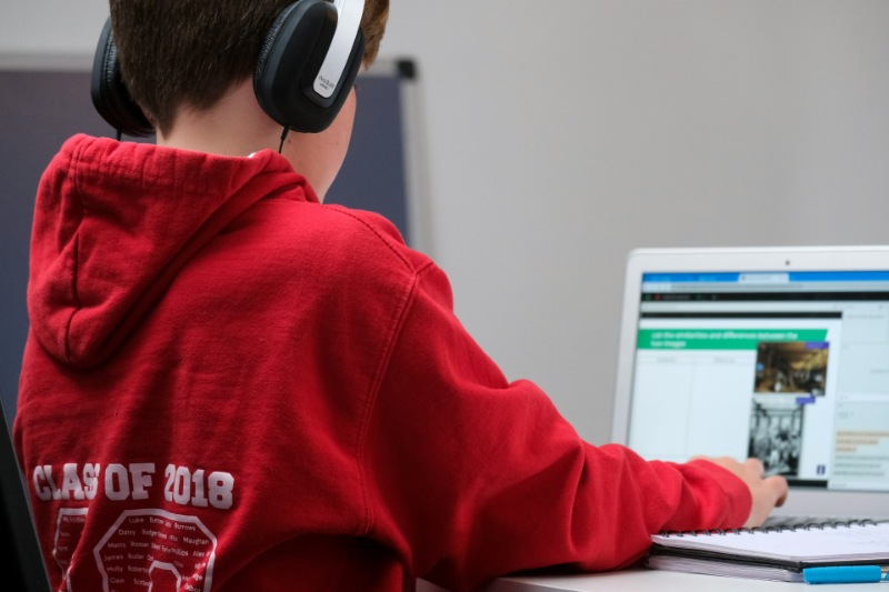 Young child using a computer in a classroom environment.