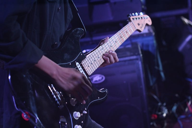 Close-up of an electric guitar being played during a performance.