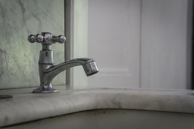 Modern bathroom tap mounted on a granite countertop.
