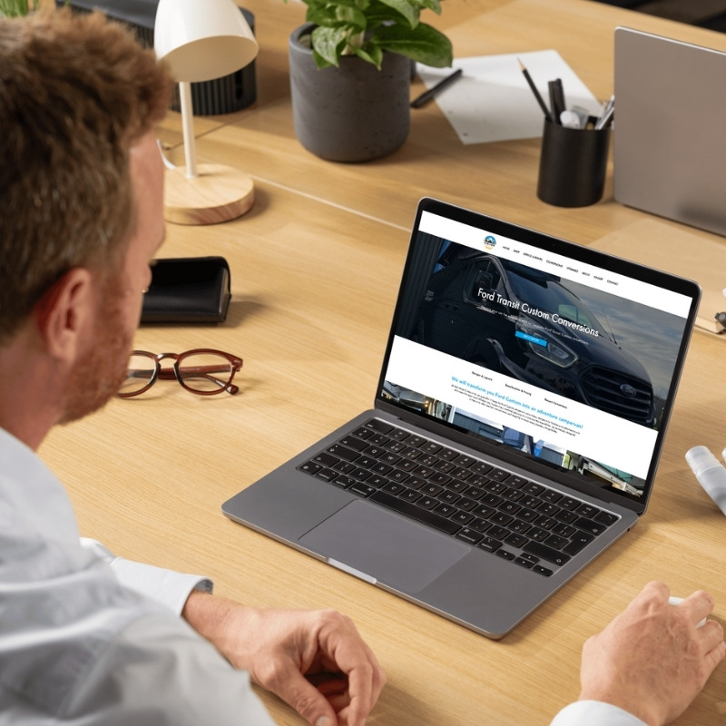 Laptop mockup showcasing the Hideaway Campervans website homepage.