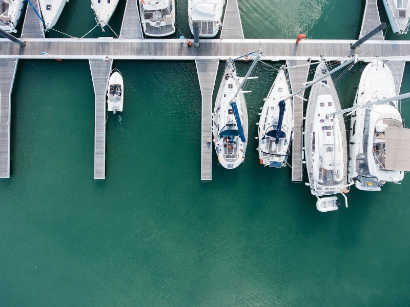 Bird’s-eye view of a marina with rows of boats moored in the water.
