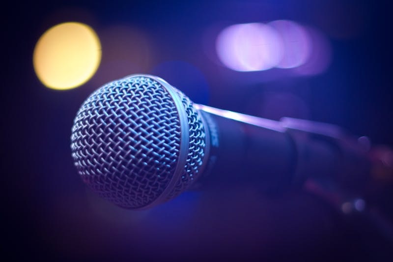 Microphone on stage under bright lights at a music festival.