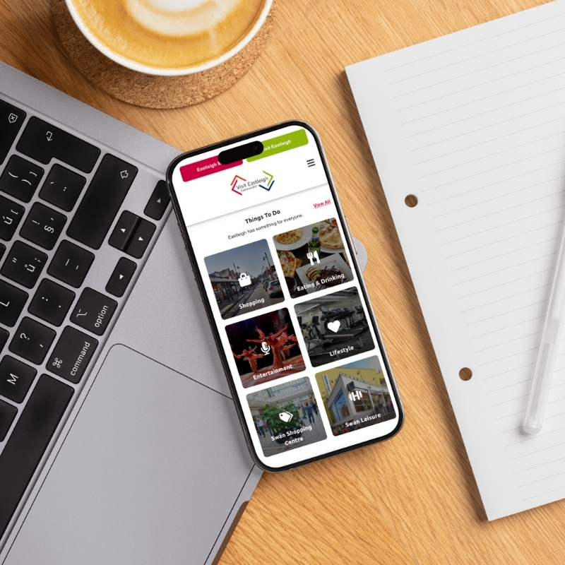 Smartphone screen mockup showing the Visit Eastleigh website design.