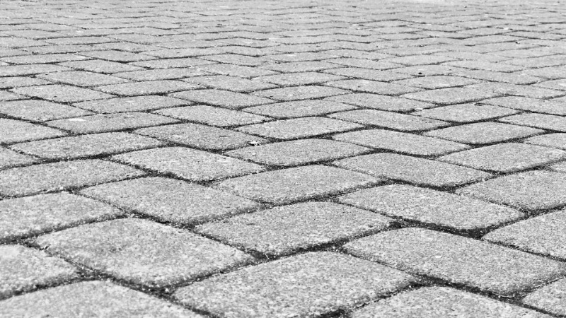 Close-up of a paved stone walkway with a textured surface.
