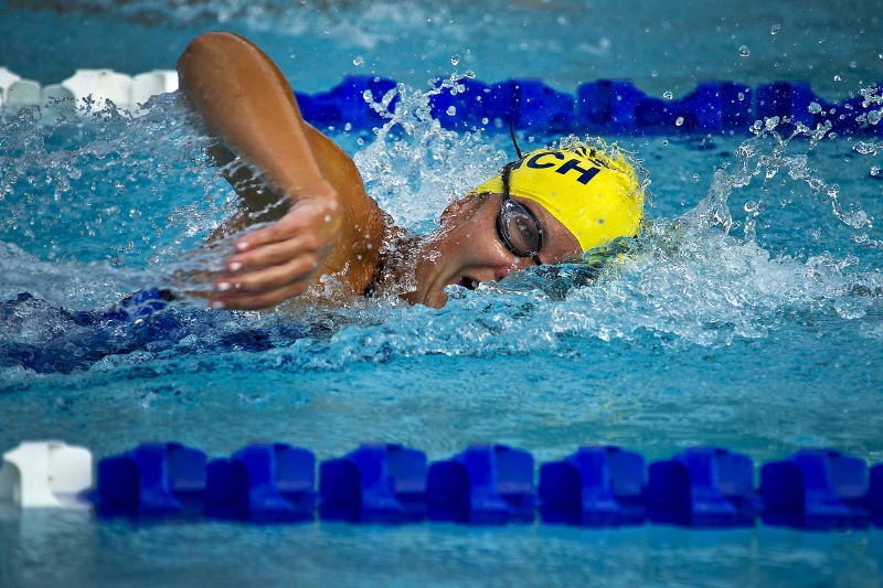 Athlete swimming front crawl in a swimming lane.