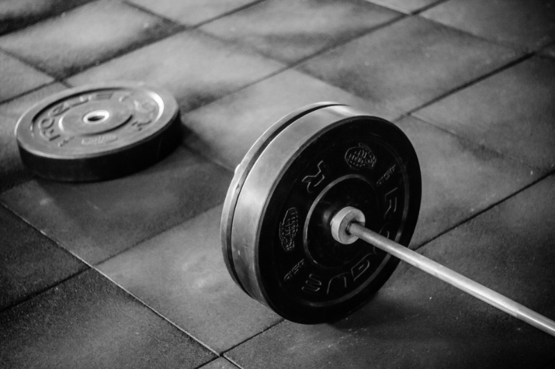 Stack of weighted bumper plates arranged on a gym floor.