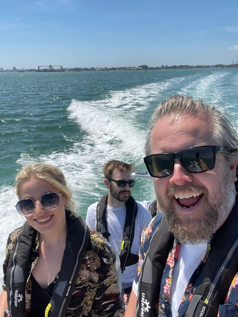Anders, Alice, and Dan smiling on a boat trip.
