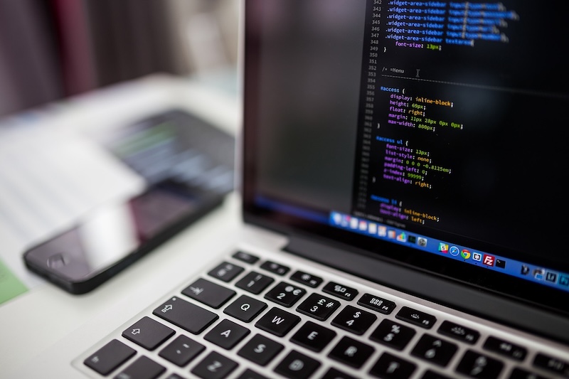 Developer working on a website design and development project on a laptop.