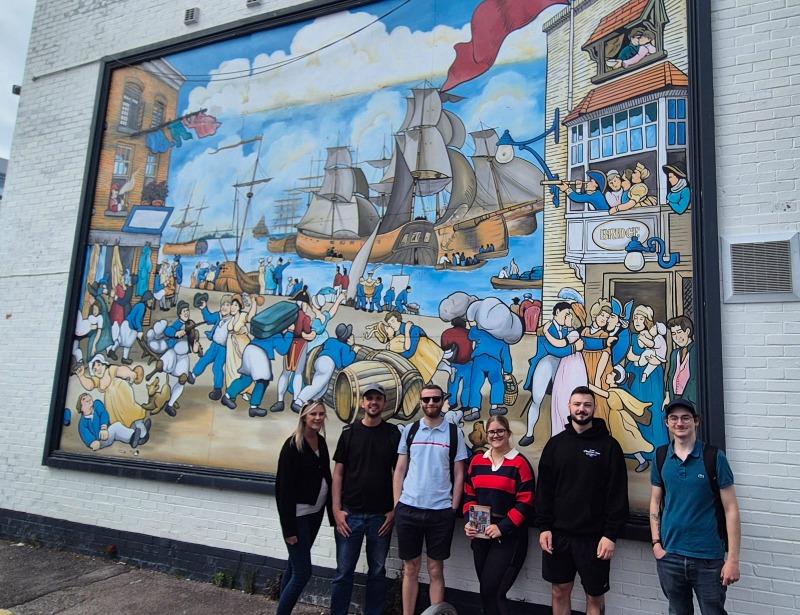 BoxChilli team posing in front of a Southsea street mural.