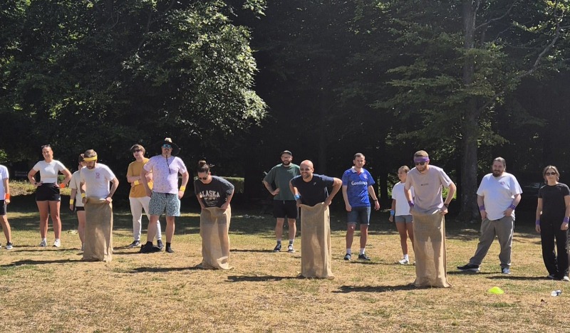 Colleagues taking part in a fun sack race during a team event.